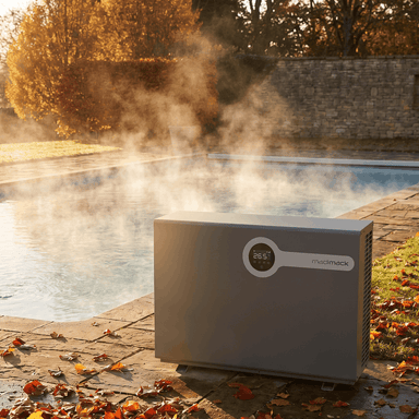 Madimack InverELITE 84K pool heater by a steaming pool in fall